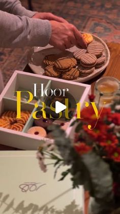 a table topped with boxes filled with cookies next to flowers and vases on top of it