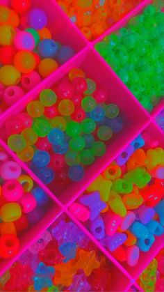 there are many different colors of beads in the bins on the table, and one is multicolored