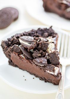 a piece of chocolate pie with oreo cookies on it and a fork next to it