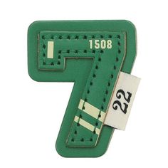 the number seven is made out of green leather and has white stitching on it