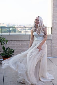 a woman in a white dress standing on a balcony