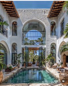 an indoor swimming pool in front of a large white building with lots of windows and doors