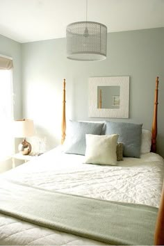 the bed is made with white sheets and pillows