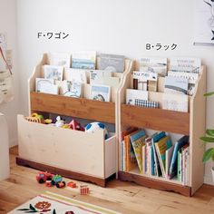 two wooden bookshelves filled with children's books on top of a hard wood floor