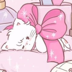 a white cat laying on top of a bed next to a pink pillow and bottle