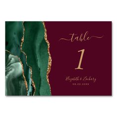 a table number card with green and gold foiling on it, featuring the number one