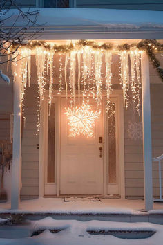 39 Winter Front Porch Decor Ideas: Inviting, Pretty Entrances Hanging Christmas Porch Decor, Snowflake Christmas Lights On House, Hanukkah Front Porch Decor, Outdoor Christmas Decorations Townhouse, White Christmas Yard Decorations, Christmas Decoration House Outdoor, Anthropologie Christmas Front Porch, Black Christmas Porch Decor, Snowflake Porch Decorations