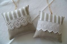 two decorative pillows with lace on them