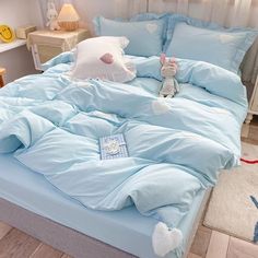 a bed with blue sheets and white pillows