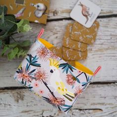 a small cup sitting on top of a wooden table next to some cards and flowers