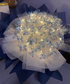 a blue and white flower with lights on it's petals in the shape of butterflies