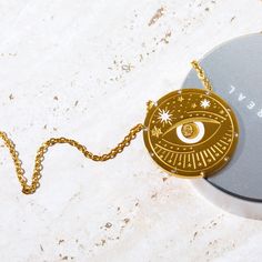 Our Celestial Coin Medallion Necklace—a captivating accessory inspired by the celestial wonders of the universe. This necklace features a stunning coin-shaped pendant crafted in gold, adorned with celestial motifs that evoke a sense of mystery and magic. With three distinct styles to choose from—moon phase, sun and moon, and evil eye—this necklace allows you to express your unique style while embracing the celestial energies that surround us. Symbolic Gold-plated Coin Necklace, Gold Mystical Necklace With Sun And Moon Design, Mystical Gold Necklace With Sun And Moon Design, Celestial Round Medallion Necklace For Gifts, Gold Plated Symbolic Medallion Necklace, Symbolic Gold-plated Medallion Necklace, Symbolic Gold Plated Medallion Necklace, Gold Necklace With Sun And Moon Design, Celestial Medallion Necklace Gift With Round Pendant