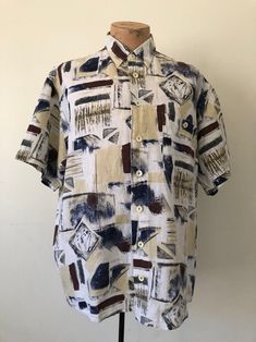 A vintage unique abstract pattern short-sleeve shirt made of linen sheer textured fabric with chest button pocket. Loose fit for comfort. Perfect summer casual shirt! Size: 43           XL Vacation Tops With Geometric Pattern And Short Sleeves, Short Sleeve Tops With Geometric Pattern For Vacation, Vacation Short Sleeve Top With Geometric Pattern, Vacation Geometric Pattern Short Sleeve Tops, Beach Tops With Geometric Pattern And Short Sleeves, Patterned Linen Short Sleeve Top, Patterned Linen Tops With Short Sleeves, Patterned Short Sleeve Shirt With Abstract Print, Casual Shirt With Abstract Pattern