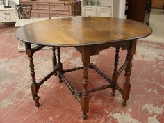 an old wooden table is on display in a room with other furniture and decor items