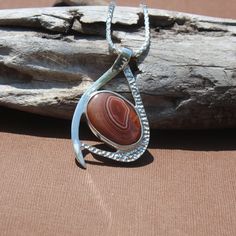 New Design! Red and White Banded Lake Superior Agate Pendant set in .950 Sterling Silver with Solid Silver Back. Total piece measures about 50 x 39mm Our reviews will tell you, If you like it here, you'll LOVE it in person! GIVE IT A TRY! If not completely satisfied with your order, contact me right away and return the item within 7 days. Instagram: www.instagram.com/agatejewelrybylarry Facebook fb.me/agatejewelrybylarry Custom work not available. Pendant chains not included. Artisan Agate Jewelry With Polished Finish, Carnelian Cabochon Jewelry For Anniversary, Red Agate Jewelry With Polished Finish, Red Oval Agate Jewelry, Carnelian Gemstone Oval Pendant Jewelry, Carnelian Gemstone Oval Pendant, Hallmarked Agate Jewelry For Anniversary, Oval Carnelian Jewelry With Natural Stones, Agate Jewelry With Stone Setting For Gifts