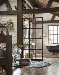 a bedroom with wood floors and exposed ceilings, an old bathtub sits in the corner