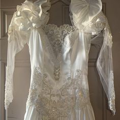 a white wedding dress hanging on a door