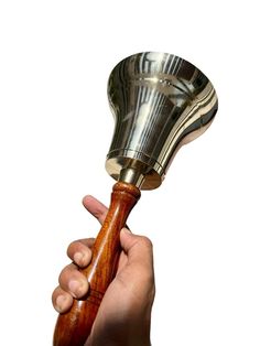 a hand holding a metal and wood object in it's right hand, against a white background