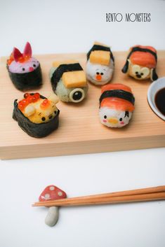 sushi on a wooden board with chopsticks next to it