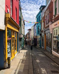 a narrow city street lined with colorful buildings