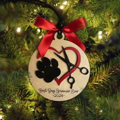 a christmas ornament hanging on a tree with scissors and heart in the center