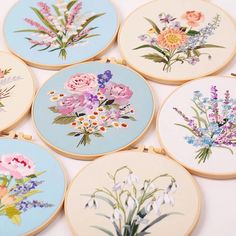 six embroidery hoops with flowers painted on them