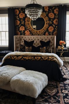 a bedroom with black and gold wallpaper, white fur rugs and a chandelier