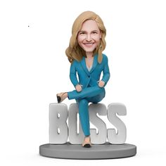 a bobble head sitting on top of the word boss with a woman's legs crossed