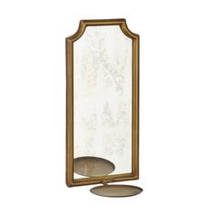 a gold framed mirror sitting on top of a table