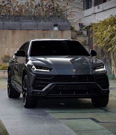 a black lamb suv parked in front of a building