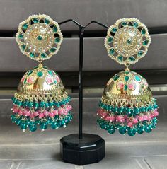 Big statement Jhumka earrings featuring a stunning turquoise and pink colour combo! The gold Kundan accents make these earrings look absolutely Royal and beautiful. They are sure to impress anyone paired with an ethnic outfit! Multicolor Latkans Earrings For Eid, Multicolor Fusion Style Festive Jhumkas, Festive Multicolor Fusion Style Jhumkas, Fusion Style Multicolor Jhumkas For Festivals, Multicolor Fusion Jhumkas For Diwali, Fusion Style Multicolor Jhumkas For Diwali, Multicolor Bollywood Jhumkas With Tilla, Green Jhumkas For Festivals And Celebrations, Green Bridal Earrings With Latkans For Celebration