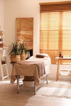 a spa room with wooden blinds and towels on the table