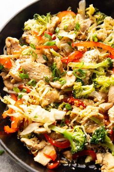 a pan filled with chicken, broccoli and peppers