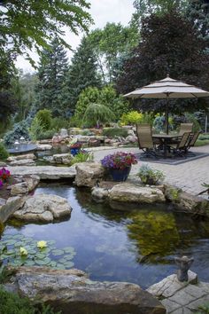 a small pond surrounded by rocks and flowers