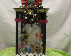 a display case with christmas decorations and presents in it on top of a green surface