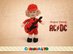 a crocheted doll holding a guitar and wearing a red outfit with the words always young ac - dc on it