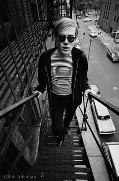 black and white photograph of man walking down stairs