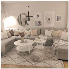 a living room filled with lots of furniture and pillows on top of a white rug