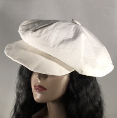 "This is an oversized newsboy style hat, made of high quality white linen.  The hat has six oversized panels.   It is generously full-bodied and can be worn close to the brow, higher on the head, cocked to the side or even backwards. This style hat will fit someone with a large to extra large size head or big hairdo, and is made to size.  I would be happy to make one for you in your size.  Remember, your hat will take 10-15 days to be made, so be sure to add this time to your expected delivery time. - Handmade - White linen  - White satiny lining - Six panels - Made to order   This newsboy hat can be made in a multitude of linen colors and patterns, and as well in denim and many luxe fleece colors and prints.  It also can be ordered in velvet, jersey, wool and in fabrics appropriate for an White Linen Hats For Spring, White Linen Hat For Spring, Adjustable Linen Flat Cap, Linen Flat Cap For Summer, White Flat Cap Hat One Size Fits Most, Summer Linen Flat Cap, Classic Linen Hat With Curved Brim, White Flat Cap For The Beach, White Flat Cap For Beach