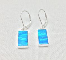 Hi everyone, just wanted to let you know we are open and shipping daily. Rectangular Blue Opal Earrings Set in 925 Sterling Silver // Lever Earwires // Blue Fire Opal Earrings Length: 1.25 inches Stone: Lab Created Fire Opal Origin: Japan Hallmark 925 Finished on the back side. Return Policy: If you are not 100% satisfied, I will exchange or refund your purchase. Returns or exchanges must be made within 14 days of purchase date of merchandise. Please include everything in the box we sent to you. Blue Sterling Silver Earrings With French Hook, Blue Rectangular Earrings With Ear Wire, Sterling Silver Blue French Hook Earrings, Blue Rectangular Earrings, Silver Opal Dangle Earrings, Blue Fire Opal Earrings, Blue Opal Multi-stone Jewelry, Blue Nickel-free Crystal Earrings, Silver Pearl Ring