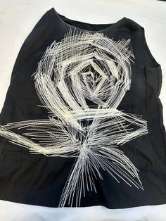 a black t - shirt with white thread work on the front and back, depicting a rose