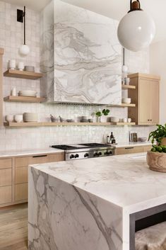 a kitchen with marble counter tops and wooden cabinets, an island in front of the stove