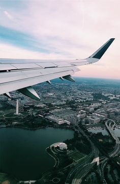 the wing of an airplane flying over a city