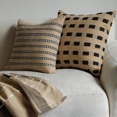 two black and tan pillows on a white couch