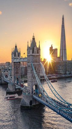 the sun is setting over tower bridge in london