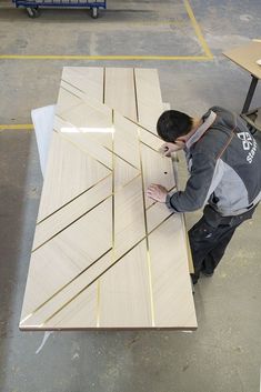 a man is working on some wooden boards