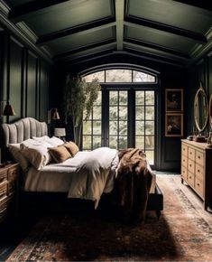 a bedroom with dark green walls and wooden furniture