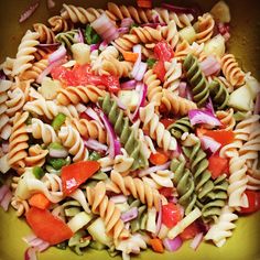 a colorful pasta salad in a yellow bowl