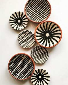 four black and white bowls sitting next to each other