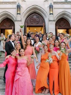 a large group of people in formal wear posing for a photo on the steps of a building